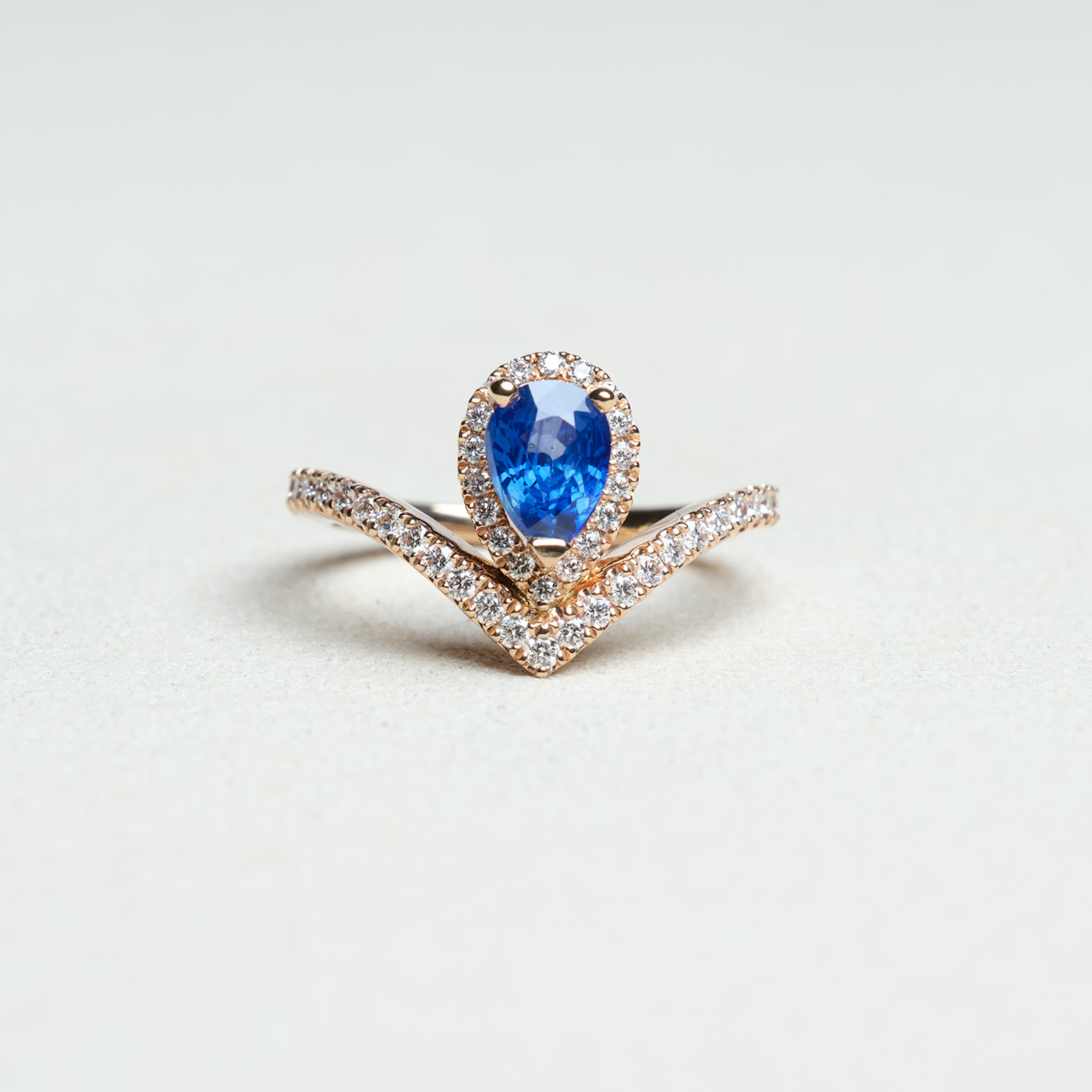 Bague Diane vue de face — saphir bleu taille poire, or rouge, pavage diamants