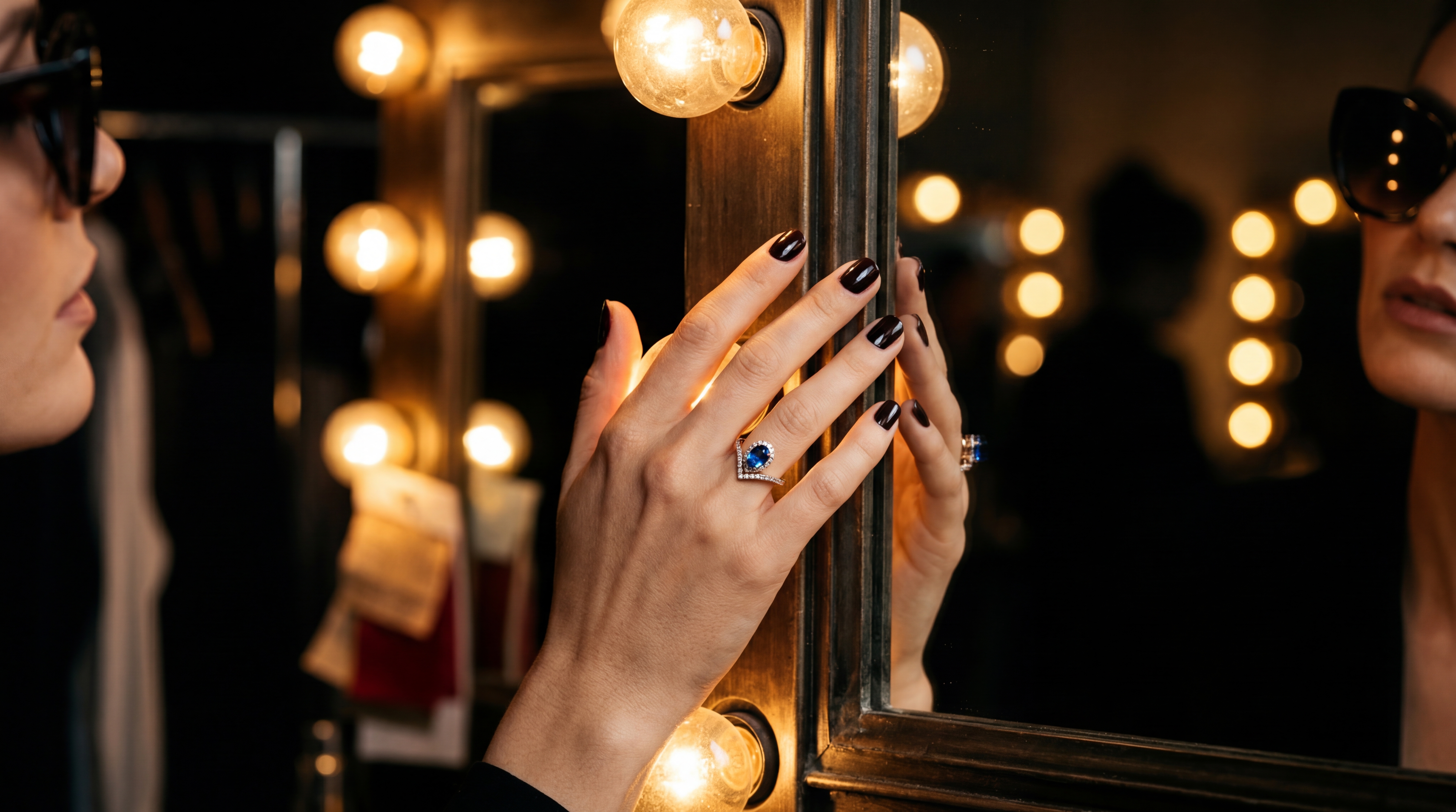 Main sur un miroir de loge, lumières vanity